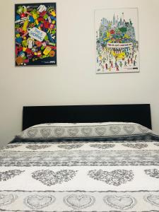 サンタンブロージョ・ディ・ヴァルポリチェッラにあるCris Apartmentsの壁に2枚の写真が飾られたベッドルームのベッド1台