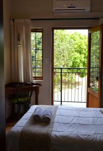 a bedroom with a bed and a view of a balcony at At Olive Guesthouse in Vanderbijlpark