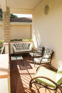 un patio con sedie e tavoli su un balcone di VIA FIRENZE a Marina di Castagneto Carducci