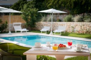 a table with a bowl of fruit next to a pool at Casale Ramunno in Ostuni