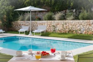a table with a plate of fruit next to a pool at Casale Ramunno in Ostuni