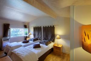 a bedroom with two beds and a window at Les Abris de Saint Sulpice - Saint-Émilion in Saint-Sulpice-de-Faleyrens