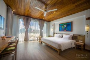 um quarto com uma cama grande e um tecto em madeira em ZEN Boutique Hoi An em Hoi An