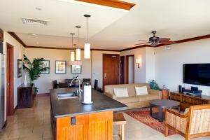 a kitchen and living room with a couch and a tv at Sixth Floor Villa with Sunrise View - Beach Tower at Ko Olina Beach Villas Resort in Kapolei