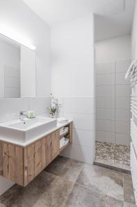 a white bathroom with a sink and a mirror at Chaletdorf-Fanningberg in Weisspriach +80 photos