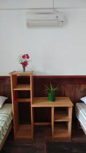 um quarto com duas camas e uma mesa com uma planta em New Raya - Nias Beach Bungalows em Lagudri