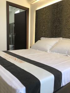 un grande letto con una coperta bianca e nera di Hotel Villa Joseph a Marotta