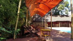 a patio with an umbrella and a table and chairs at Le Village Diego in Diego Suarez