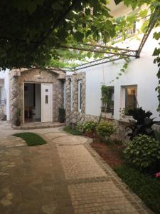 a house with a stone walkway in front of it at Apartments Vila Monegro in Bar