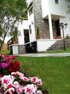 a house with a bunch of flowers in the grass at La Mora Casa de Campo in Huasca de Ocampo