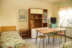 a bedroom with a bed and a table and chairs at VIA DELLA SOGLIOLA in Marina di Castagneto Carducci