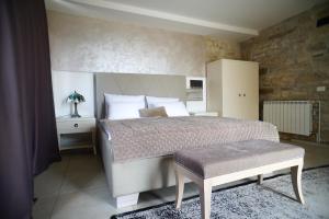 ein Schlafzimmer mit einem Kingsize-Bett und einem Hocker in der Unterkunft Stancija Ruseti in Oprtalj + 116 Fotos