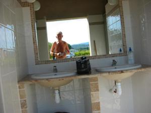 a man standing in front of a mirror in a bathroom at La Grange de Campaulise - Camping à la ferme - Hébergements - Mont Ventoux in Mazan +21 photos