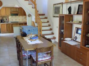 a kitchen and dining room with a table and stairs at Casa Vacanze Gardenia in Solanas +18 photos