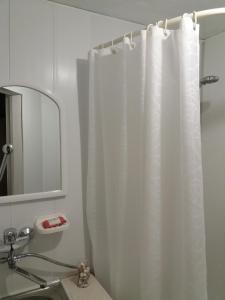 a bathroom with a white shower curtain and a sink at Гостевой дом in Odesa
