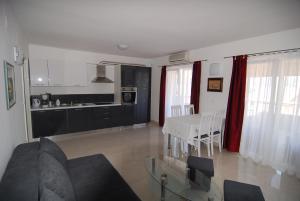 ein Wohnzimmer mit einem Sofa und einem Tisch sowie eine Küche in der Unterkunft Villa Natalie in Omiš