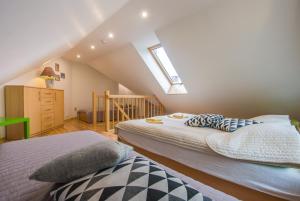 a attic bedroom with two beds and a staircase at Willa Afekt in Świnoujście