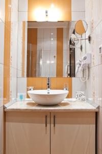 ein Badezimmer mit einem weißen Waschbecken und einem Spiegel in der Unterkunft Efbet Hotel in Warna