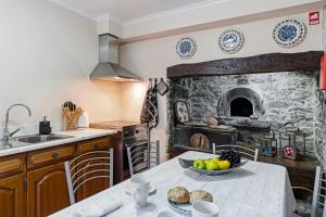 a kitchen with a table with a bowl of fruit on it at Casa da Aldeia by An Island Apart in Câmara de Lobos