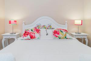 una camera da letto con un letto bianco con due lampade di Casa da Aldeia by An Island Apart a Câmara de Lobos