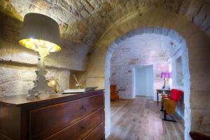 a lamp on a dresser in a room with a brick wall at Casale Ramunno in Ostuni