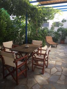 a wooden table and chairs on a patio at Anna's Studio in Piso Livadi
