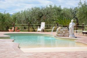 una estatua junto a una piscina con una fuente en Casale Fusco, en Spoleto