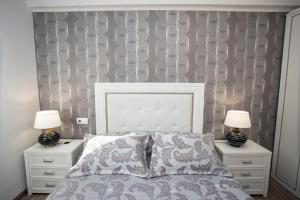 a bedroom with a bed with two nightstands and two lamps at La Mirada in Castellón de la Plana