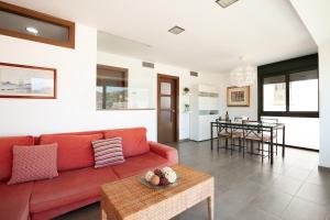 ein Wohnzimmer mit einem roten Sofa und einem Tisch in der Unterkunft Lets Holidays Passeig del Mar in Tossa de Mar
