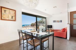 ein Esszimmer mit einem Tisch, Stühlen und einem Sofa in der Unterkunft Lets Holidays Passeig del Mar in Tossa de Mar