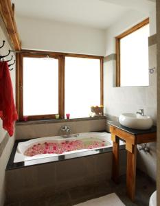 a bathroom with a bath tub with pink flowers in it at 36 Palms Boutique Retreat in Cherai Beach