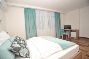 a bedroom with a bed and a desk with a computer at Motel As in Hadžići