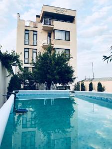 a hotel with a swimming pool in front of a building at Hotel King Tom in Tbilisi City