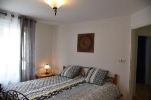 um quarto com uma cama e um relógio na parede em Le brin d'osier em Kaysersberg