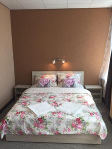 a bed with a floral bedspread and pillows on it at Sveciu Namai- Kazlu Ruda in Kazlų Rūda