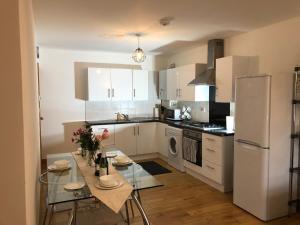 ロンドンにあるLuxurious Apartment "N22"のキッチン(テーブル、白い冷蔵庫付)