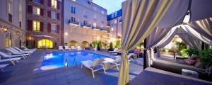 a pool in a courtyard with chairs and a building at Maison Dupuy Hotel in New Orleans