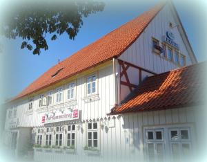ein großes weißes Gebäude mit rotem Dach in der Unterkunft Hotel Kammerkrug in Bad Harzburg