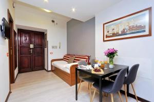 ローマにある4BNB - Cavour Square Apartmentのベッド、テーブル、椅子が備わる客室です。