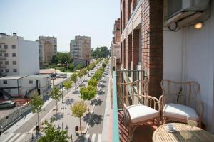 a balcony with chairs and trees on a city street at Tendency Rambla del Poblenou in Barcelona