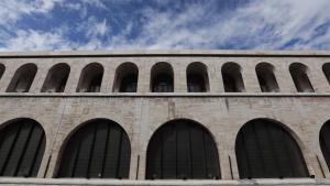 un edificio in mattoni con finestre ad arco contro un cielo blu di Suite Inn Rome a Roma