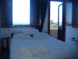 a bedroom with a white bed with towels on it at Theresa Hotel at Karpaz Peninsula in Ayia Trias