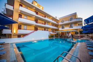 a large swimming pool in front of a hotel at Erato Studios & Apartments in Kos