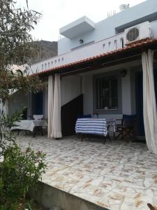 a house with a patio with a table and a bench at Sylvia's houses in Kalymnos