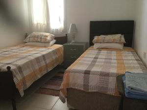 a bedroom with two beds and a dresser and a window at Aphrodite Beachfront Apartment in Ghaziveran +67 photos