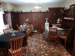 a dining room with tables and chairs and a refrigerator at Colonial Charm Inn Bed & Breakfast in Charlottetown