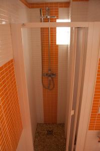 y baño con ducha de azulejos de color naranja. en Homely Nest Valencia El Carme en Valencia