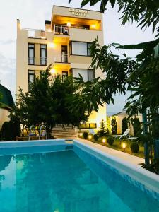 un hotel con piscina frente a un edificio en Hotel King Tom, en Tiflis
