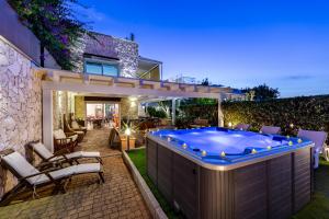 a hot tub in the backyard of a house at Hotel Residence Hibiscus in La Caletta