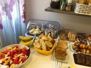 einen Tisch mit verschiedenen Brotsorten und Früchten in der Unterkunft B&B Tre passi CIR 23091 in Verona